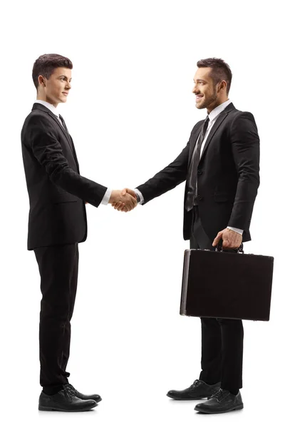 Young man in a suit shaking hands with a businessman — Stock Photo, Image
