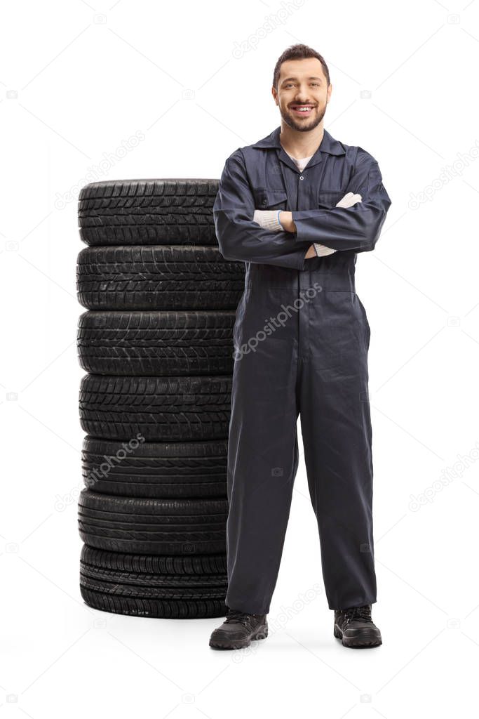 Automechanic standing next to a pile of tires