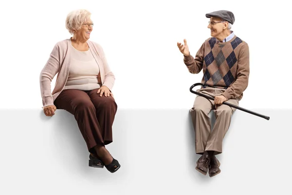 Ανώτερος άνδρας μιλάει σε μια ηλικιωμένη γυναίκα, ενώ κάθεται σε ένα κενό pa — Φωτογραφία Αρχείου