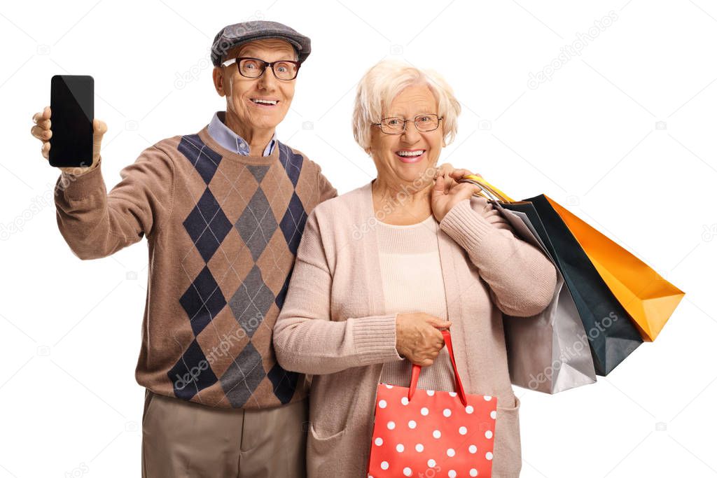 Smiling senior people with a mobile phone and shopping bags 