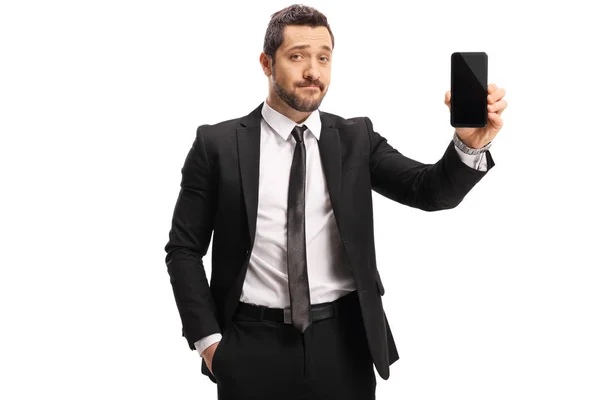 Deluso giovanotto in giacca e cravatta che mostra un cellulare — Foto Stock