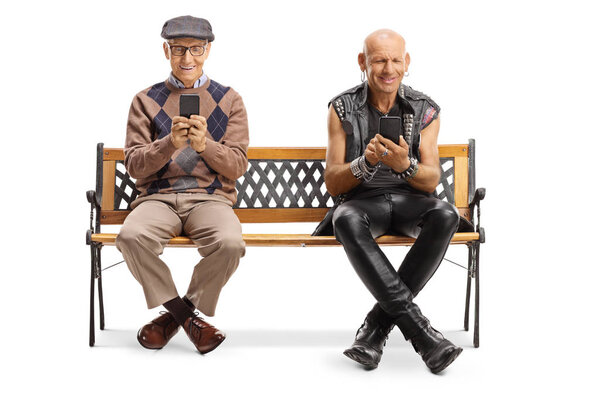 Elderly man and a punker using mobile phones and sitting on a be