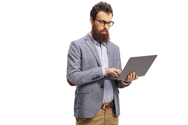Baard man met een serieuze uitdrukking werken op een laptop — Stockfoto