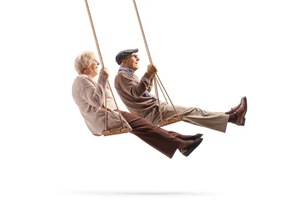 Пожилые мужчины и женщины, качающиеся на деревянных качелях — стоковое фото