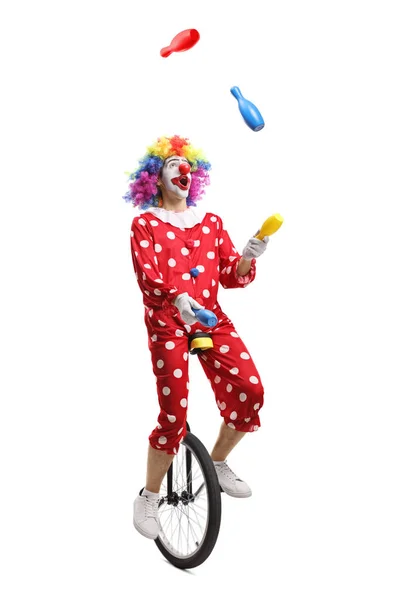 Клоун на одноколесном жонглировании — стоковое фото