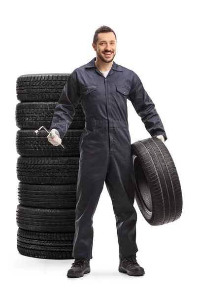 Car mechanic holding a tire and a wrench — Stock Photo, Image