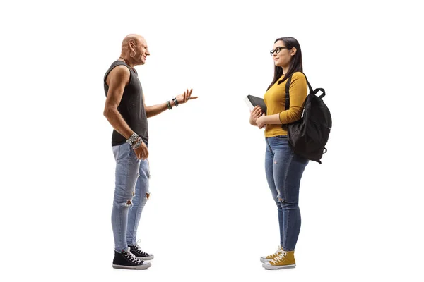 Erkek hippi elinde kitap tutan bir kız öğrenciyle konuşuyor. — Stok fotoğraf