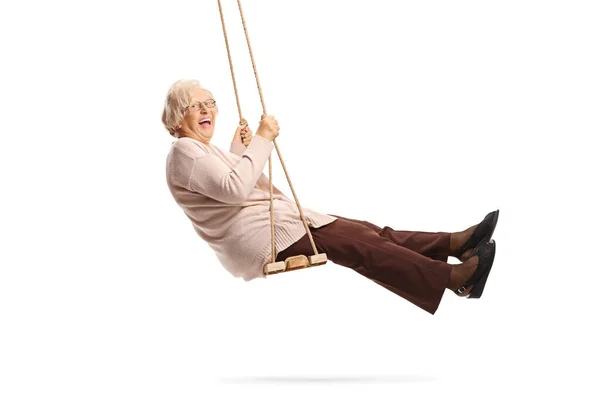 Senior dame swingen op een schommel en lachen — Stockfoto