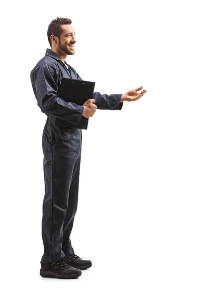 Üniformalı bir erkek işçi ayakta ve el kol hareketi yapıyor. — Stok fotoğraf