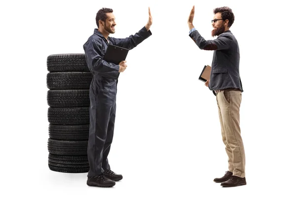 Auto mechanic gesturing high-fve with a bearded man — Stock Photo, Image