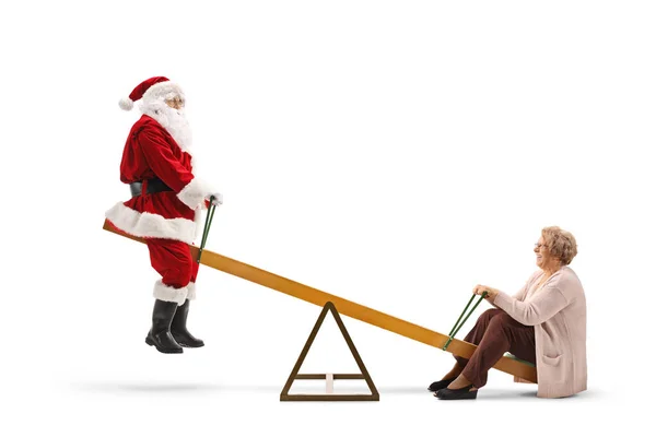 Weihnachtsmann reitet mit einer älteren Dame auf einer Wippe — Stockfoto