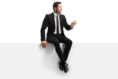 Boş bir panelde oturan takım elbiseli yakışıklı bir genç.