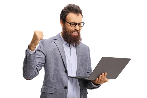 Bärtiger Mann mit gestikulierendem Erfolg und Blick auf einen Laptop — Stockfoto