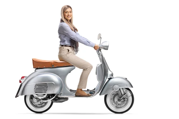Mujer joven sentada en un scooter vintage y sonriendo al llegar —  Fotos de Stock