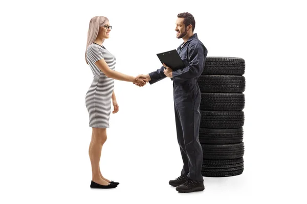 Otomobil tamircisi genç bir bayan müşteriyle el sıkışıyor. — Stok fotoğraf
