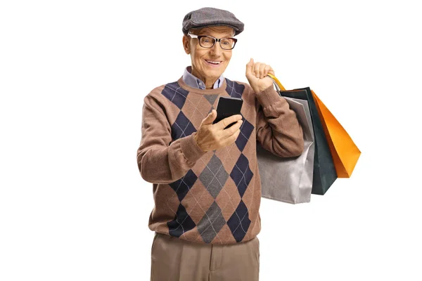Szczęśliwy senior z telefonem komórkowym i torbami na zakupy — Zdjęcie stockowe