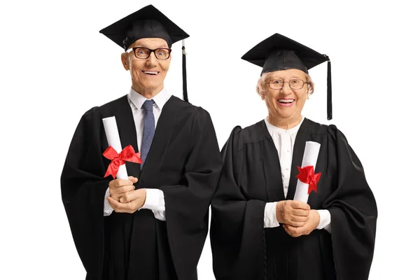 Personas de edad avanzada en trajes de graduación con diplomas — Foto de Stock