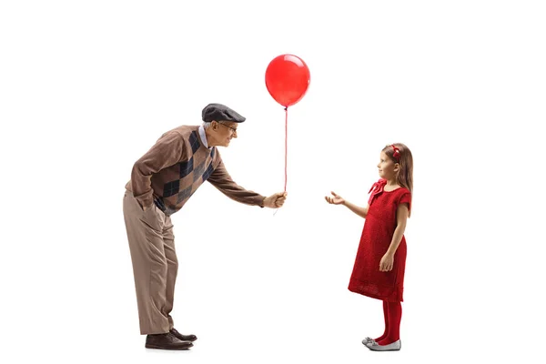 祖父が孫娘に赤い風船をあげて — ストック写真