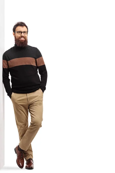 Bearded man in a turtleneck cardigan leaning on a wall — Stock Photo, Image