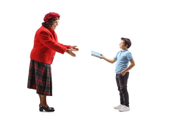 Boy giving a book to an older lady — Stock Photo, Image