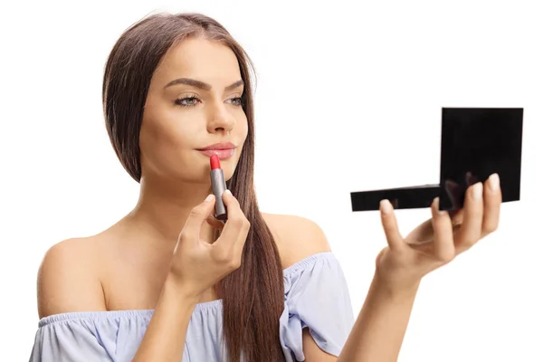 Young beautiful woman applying lipstick and holding a small mirr — Stockfoto