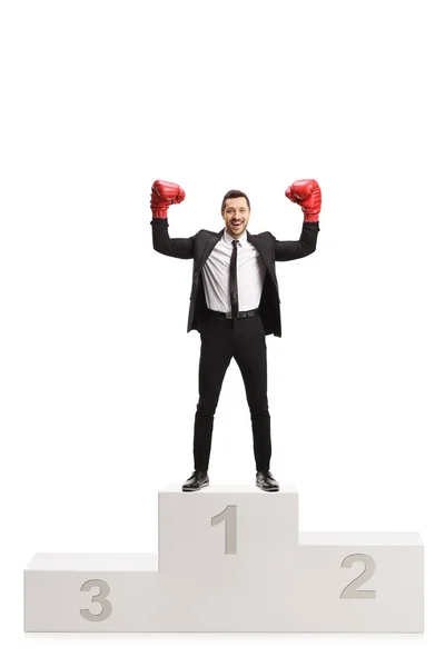 Man in a black suit and red boxing gloves standing on a first pl — Stockfoto