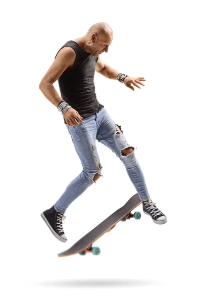 Лысый парень прыгает со скейтбордом — стоковое фото