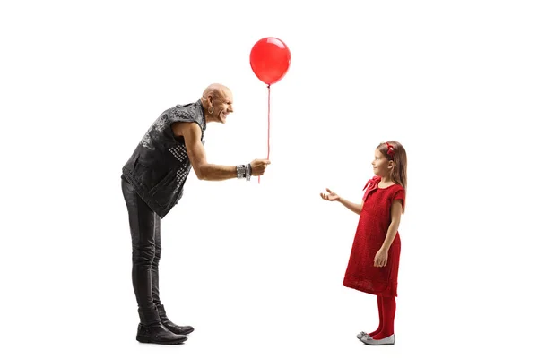 Rock star giving a red balloon to a little girl — Stock Photo, Image