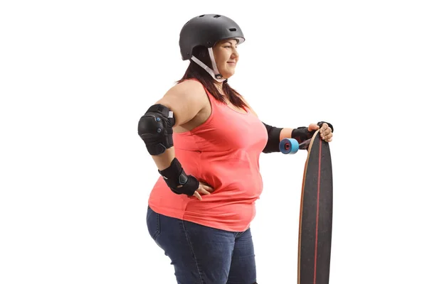 Chubby woman with protective gear and a longboard — Stockfoto