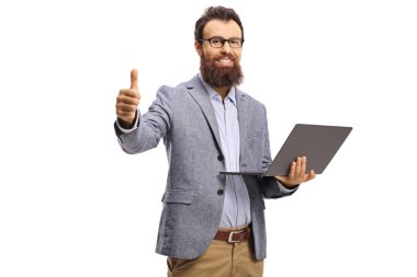 Sırıtkan sakallı adam dizüstü bilgisayar tutuyor ve başparmaklarını gösteriyor.
