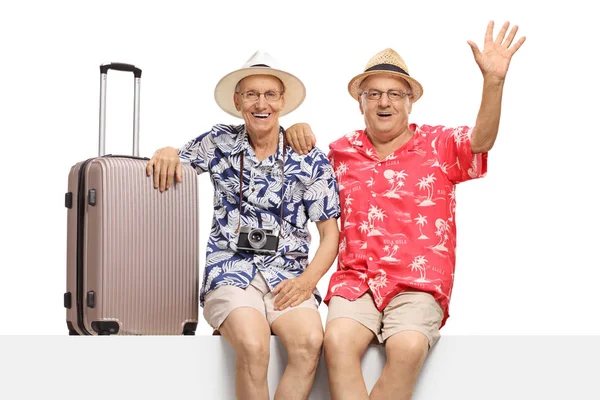 Senior männliche Touristen sitzen auf einem Panel mit einem Koffer und Wellness — Stockfoto