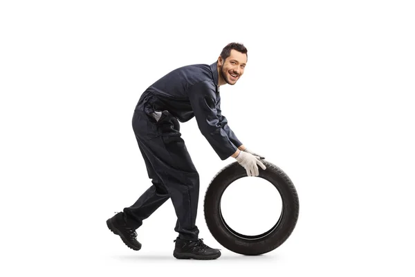 Mécanicien automobile roulant un pneu de voiture — Photo