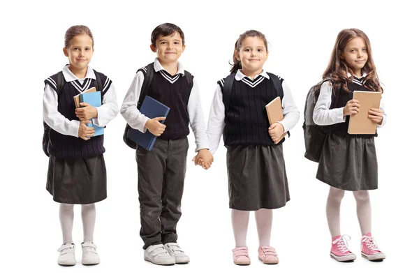 Três alunas e um menino de escola usando uniformes escolares — Fotografia de Stock