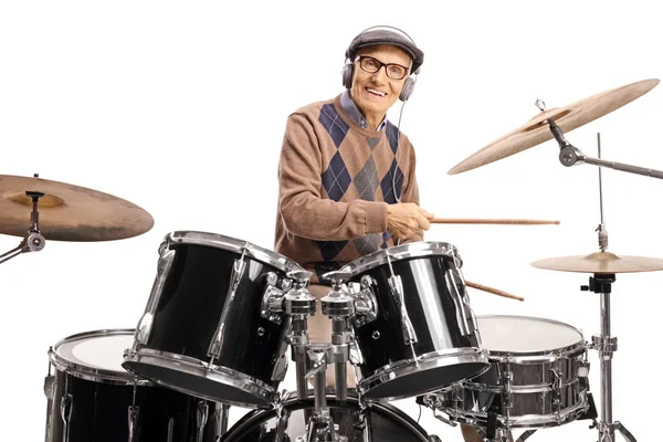 Senior man med hörlurar spelar på trummor — Stockfoto