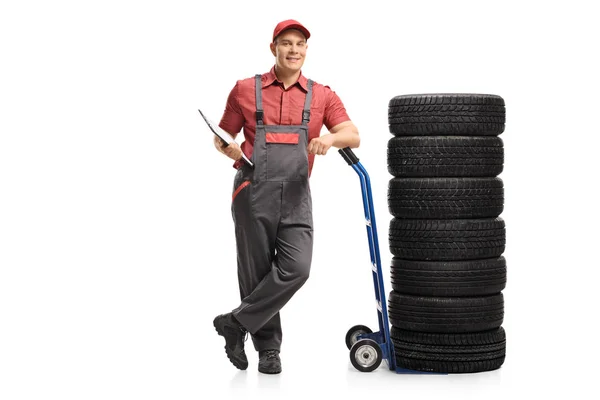 Werknemer met een klembord leunend op een handtruck met voertuig tir — Stockfoto
