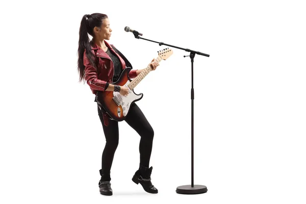 Musicista femminile con una chitarra che canta su un microfono — Foto Stock