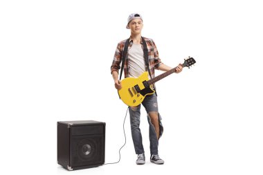 Elektro gitarı ve amplifikatörü olan genç bir adam.
