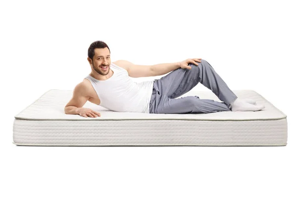 Jonge knappe man liggend op een bed matras — Stockfoto