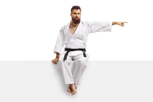 Férfi karate kimonó fekete öv ül egy üres panel egy — Stock Fotó