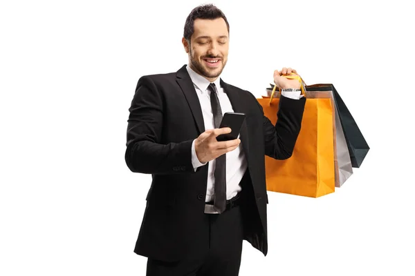 Empresario con bolsas de compras y un smartphone — Foto de Stock