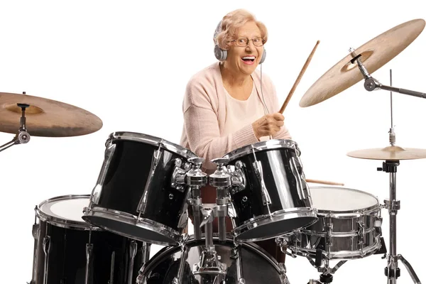 Mulher idosa feliz com fones de ouvido tocando bateria — Fotografia de Stock