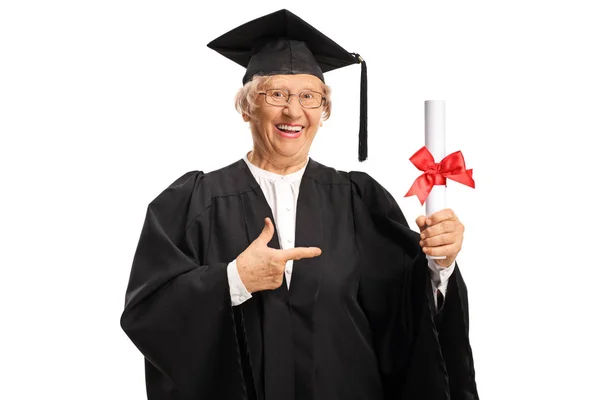 Oudere vrouw in een afgestudeerden jurk met een diploma en een punt — Stockfoto