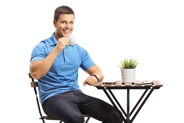 Joven bebiendo café en una mesa — Foto de Stock