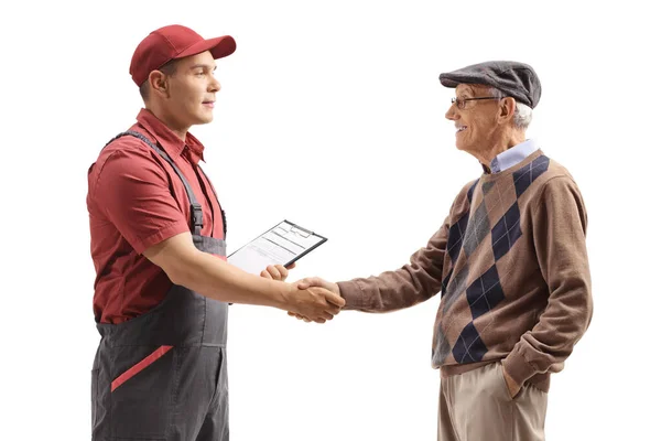 Mannlig arbeider håndhilser på en eldre mann – stockfoto