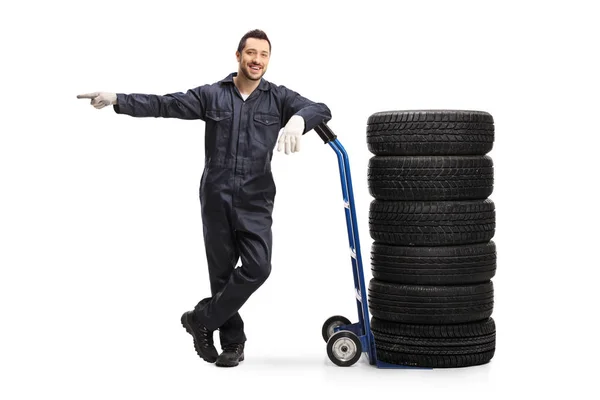 Auto monteur leunend op een handtruck met banden en wijzen — Stockfoto