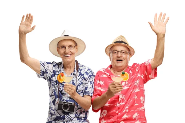 Cheerfull senior men on a holiday holding cocktails and waving — Stock Photo, Image