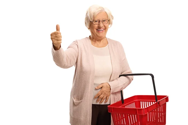 Mujer mayor mostrando un pulgar hacia arriba y sosteniendo una compra vacía — Foto de Stock