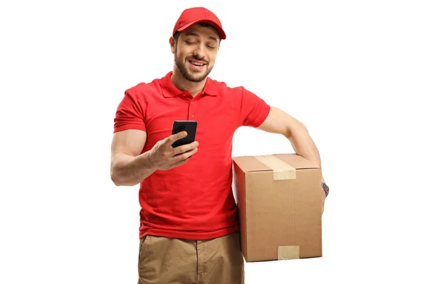 Leverans kille som håller en låda och tittar på en mobiltelefon — Stockfoto