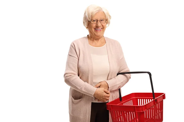 Seniorin lächelt und hält leeren Einkaufskorb in der Hand — Stockfoto