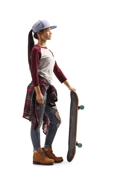 Jonge vrouw met een pet en een skateboard — Stockfoto